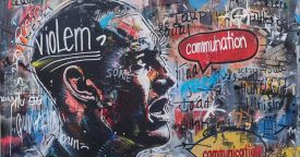 Murales con faccia di un uomo e parole intorno che evidenziano la comunicazione nonviolenta